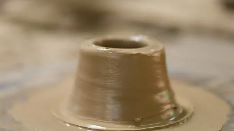 Artisan Hands Shaping Wet Clay on a Spinning Pottery Wheel Stock Footage 341536319