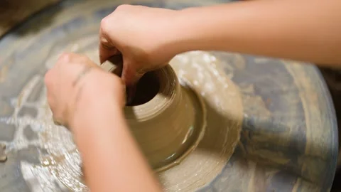 Artisan Hands Shaping Wet Clay on a Spinning Pottery Wheel Stock Footage 341536426
