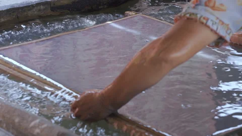 Artisan lifting paper pulp screen from water in Thailand, mulberry paper process Stock Footage 329925019