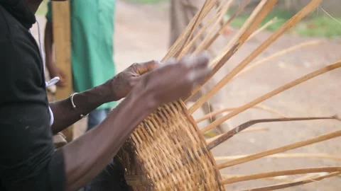 An artisan makes a basket with his hands in a small village, in Ivory Coast Stock Footage 237985857