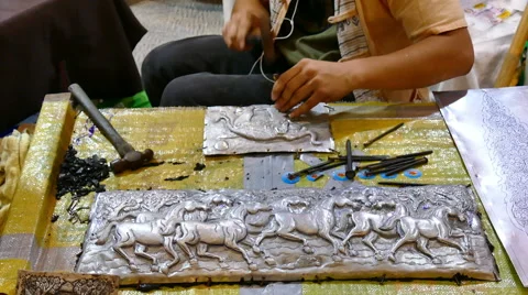 Artisan man demonstrating how to carve silver sculpture art Stock Footage 64937591