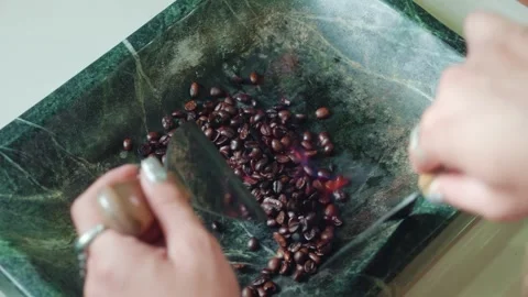Artisan manual coffee roasting process with metal spatulas and low fire on Stock Footage 336637652
