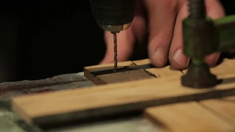Artisan pierces a flat metal bracket with a drill Stock-Footage 100984573