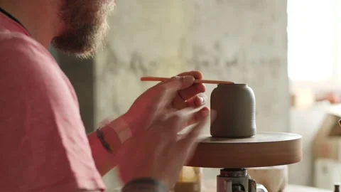 Artisan potter aligns the clay teapot on the potter's wheel Stock Footage 145543929