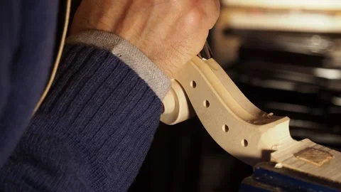 Artisan precisely gouges the fluting of a violin scroll secured in a 스톡 동영상 313269489