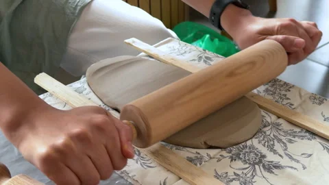 Artisan rolling out a slab of clay with a wooden rolling pin Видео 341055425