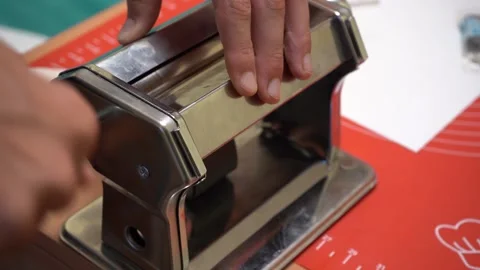 Artisan rolls black piece of polymer clay in pasta machine making gradient Stock Footage 239241578