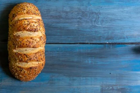 Artisan seed bread on a blue table, ideal for tapas or sandwiches Stock Photos