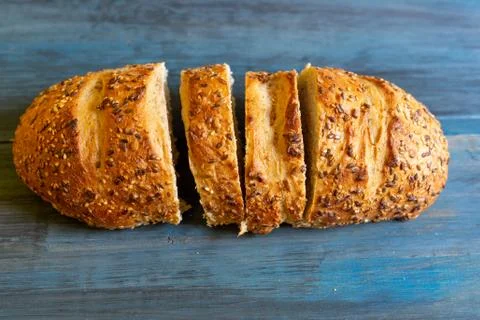 Artisan seed bread on a blue table, ideal for tapas or sandwiches Stock Photos