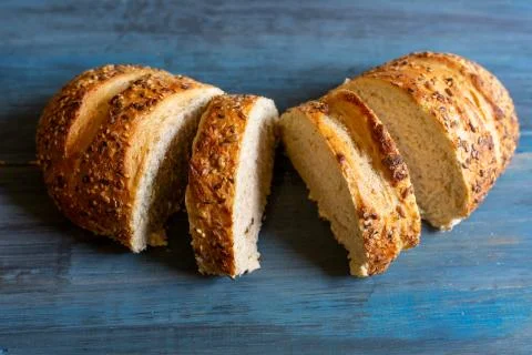 Artisan seed bread on a blue table, ideal for tapas or sandwiches Stock Photos