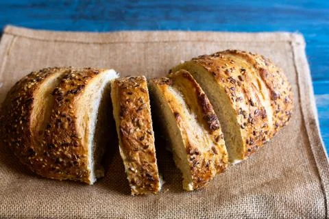 Artisan seed bread on a blue table, ideal for tapas or sandwiches Stock Photos