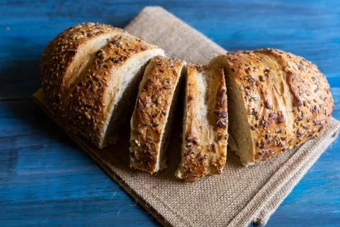 Artisan seed bread on a blue table, ideal for tapas or sandwiches Stock Photos