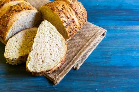 Artisan seed bread on a blue table, ideal for tapas or sandwiches Stock Photos