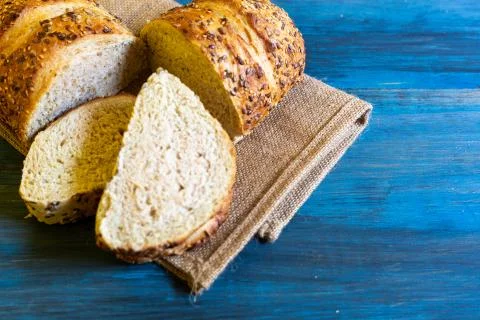 Artisan seed bread on a blue table, ideal for tapas or sandwiches Stock Photos