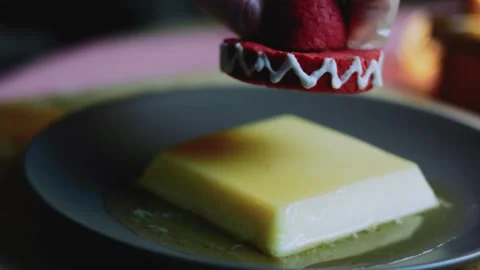 Artisan tabletop study of placing a red miniature sombrero over the flan Stock Footage 342154150