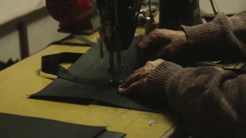 Artisan tailor sewing black fabric on a vintage machine Stock Footage 345898471