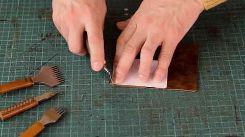 Artisan uses a knife to round the corners of the leather cardholder. Stock Footage 150480500