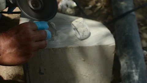 Artisan using an angle grinder to cut and shape seashell fragments for jewelry Stock Footage 337910025
