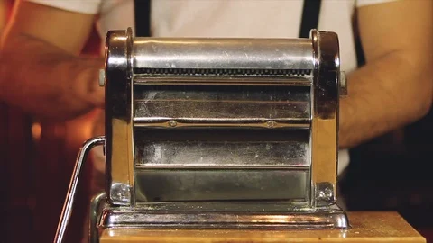 Artisan is using the classic machine Italian to spread the dough with a roller. Stock Footage 101620379