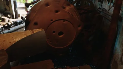 Artisan using a lathe machine in a rustic workshop with tools on the wall Stock Footage 262025407