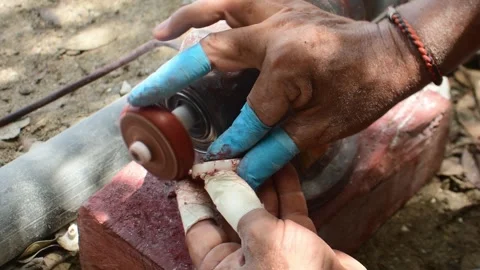 Artisan using a rotary tool to polish and refine a small organic material piece Video stock 337910041