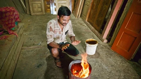 Artisan warms hands by fire in carpentry shop Stock Footage 301437663