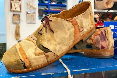 Artisanal Patchwork Leather Shoe on a Workshop Bench 스톡 사진