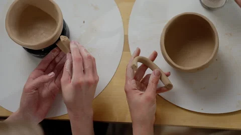 Artisanal pottery making session with two individuals shaping clay on a table Stock Footage 271151199