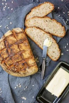 Artisanal rustic bread sliced and butter. Stock Photos