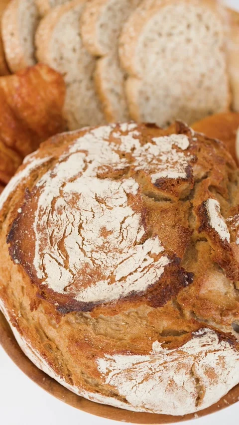 Artisanal Sourdough Loaf and Assorted Bakery Pastries on White Background Stock Footage 338041859