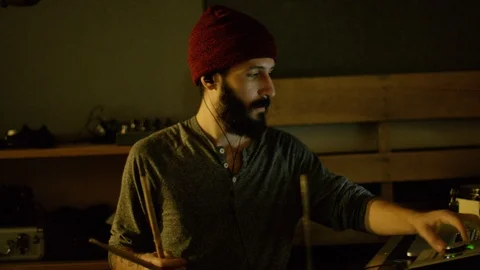 Artist adjusting digital recorder while playing drum set Stock Footage 108920635