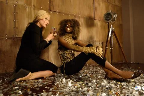 Artist applying makeup to beautiful african american model at photo shoot on  Stock Photos
