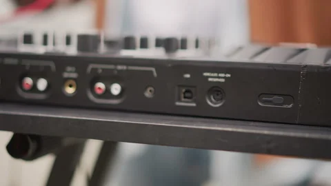 Artist arranging red cable for keyboard connection outdoors, Busker methodically Stock Footage 346367563