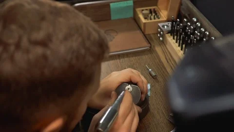 Artist is busy creating a silver ring and choosing a drill for processing Stock-Footage 73528002