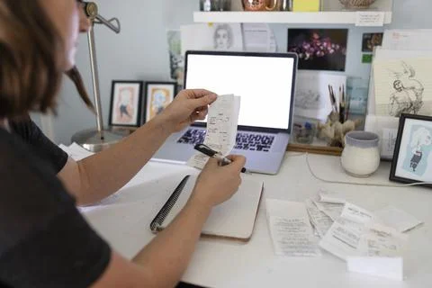 Artist checking her receipts using laptop Stock Photos