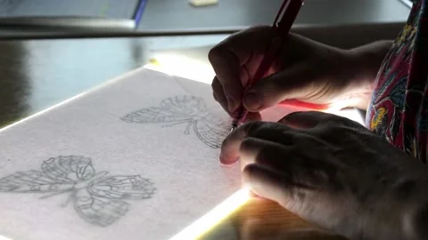 The artist copies the drawing on the light table Stock Footage 155848193
