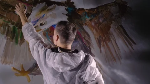 Artist designer draws an eagle on the wall. Craftsman decorator paints a picture Stock Footage 120802586