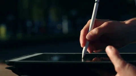 Artist drawing a sketch on tablet using stylus at park Vidéo 82360653