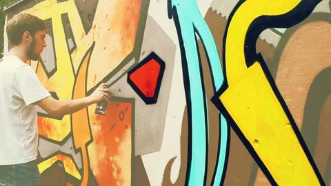 The artist draws graffiti on a fence. | Stock Video | Pond5