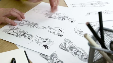 The artist draws on paper characters for computer games or comics. Stock Footage 245744513