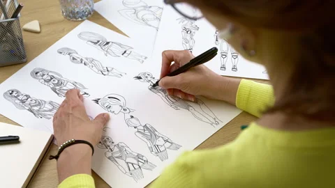 The artist draws on paper characters for computer games or comics. Stock Footage 245744686