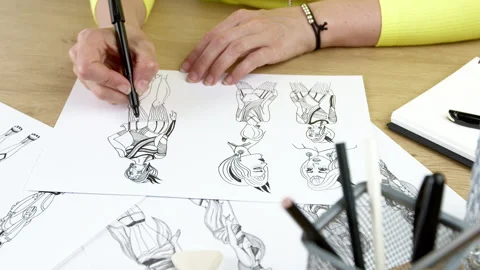 The artist draws on paper characters for computer games or comics. Stock Footage 245747830