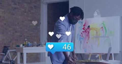 Artist holding canvas while like count popping hearts confetti, using laptop for Stock Footage 311946909