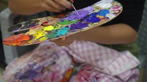 Artist Holding Vibrant Multi-Colored Wooden Paint Palette Stock Footage 333562789