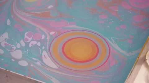 An artist making the paint drops on ebru technique picture slow motion Stock Footage 74719528