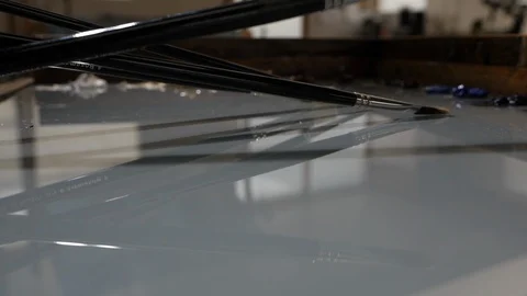 Artist paint brushes drop onto table palette in slow motion Stockbeeldmateriaal 104269020