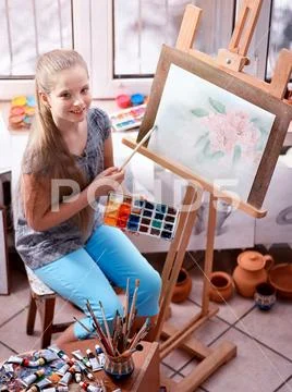 Artist Painting On Easel In Studio. Girl Paints With Brush.