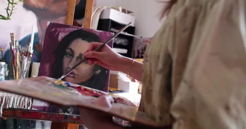 Artist painting self portrait in oil paints on a canvas Stock Footage