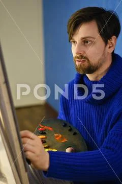 Artist paints oil paints on canvas Stock Photos