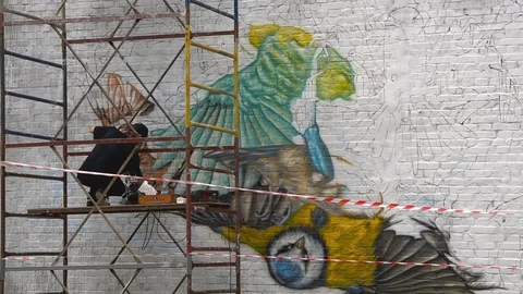 Artist paints on the wall using sprayer Stock Footage 80931672